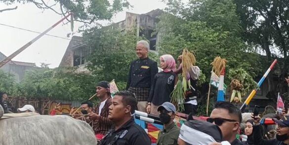 Capres Ganjar Pranowo didampingi isteri tercintanya, Atiko dan puteranya, Alam Ganjar berdiri di atas gerobak kirab. @foto:repro